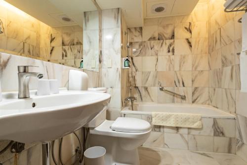 台中市沫秋立柳川行旅的浴室配有盥洗盆、卫生间和浴缸。