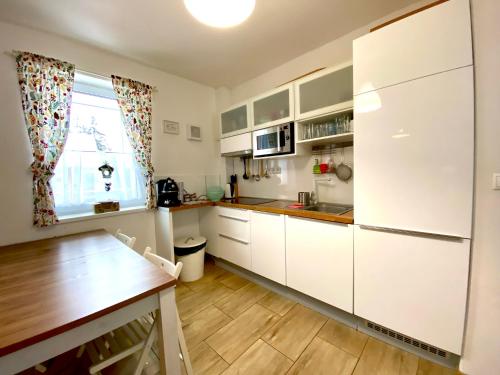 迪马诺卡多林纳Chalet 3 Domky 182的厨房配有白色橱柜和木桌