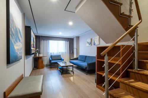 上海上海陆家嘴滨江大道亚朵X酒店的客厅设有蓝色的沙发和楼梯。