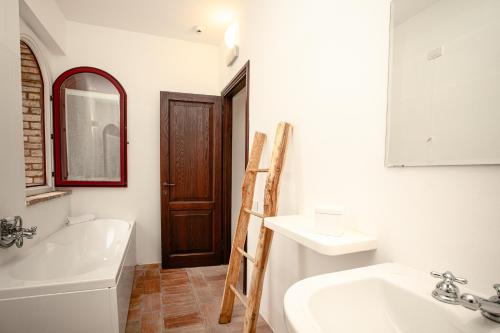 奇尼基亚诺Tenuta Pianirossi的一间带水槽、浴缸和镜子的浴室
