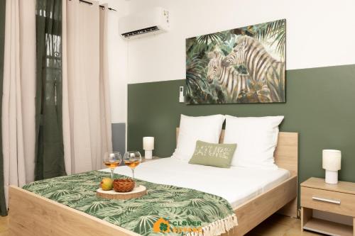 卡宴Le Lodge Safari au centre-ville的一间卧室配有一张带两杯葡萄酒的床