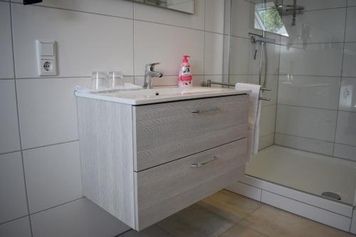 温特贝格Ferienwohnung (H)Auszeit Pape的白色的浴室设有水槽和淋浴。