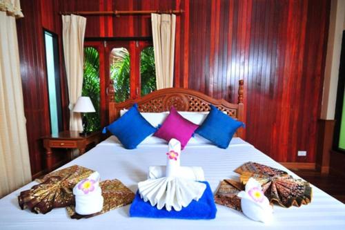 帕干岛Haad Yao Bayview Hotel的卧室配有白色的床和色彩缤纷的枕头