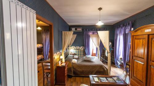 索拉Portella delle Fate的一间卧室配有一张蓝色墙壁和紫色窗帘的床