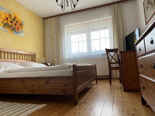 Landgasthof Faymann的卧室配有床、椅子和窗户。