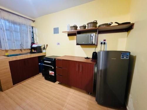 Langata RongaiLovely 2 Bedroom Apartment in Ongata Rongai的厨房配有冰箱和台面