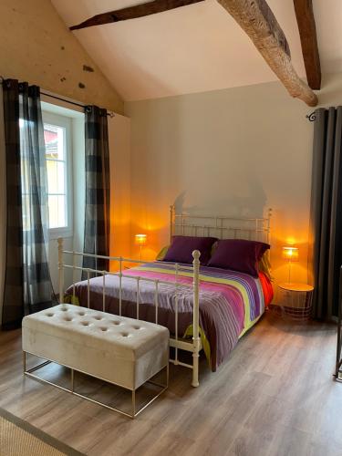 波城Loft de charme en centre-ville的一间卧室配有一张床、一张长凳和一个窗户。