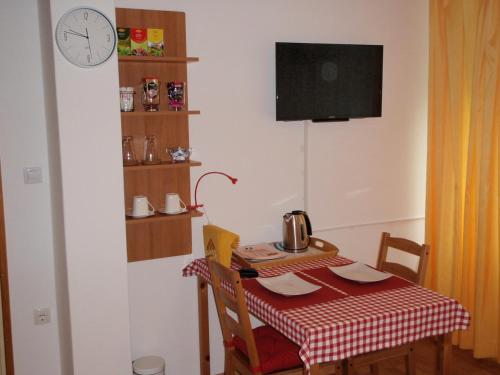 博维茨Sobe Vera的一个带桌子和墙上时钟的小厨房