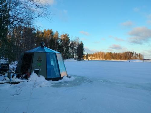 萨翁林纳Aurora Hut Savonlinna的冰冻湖上雪中的蓝色帐篷