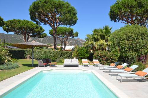 卡尔维Domaine Villas Mandarine Private Pools & Spa的一个带躺椅和遮阳伞的游泳池