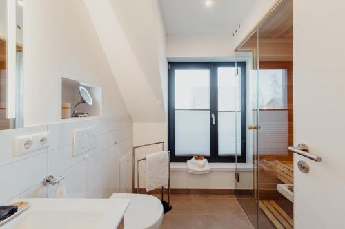 普鲁滕SandDorn 1 und 2的白色的浴室设有卫生间和窗户。