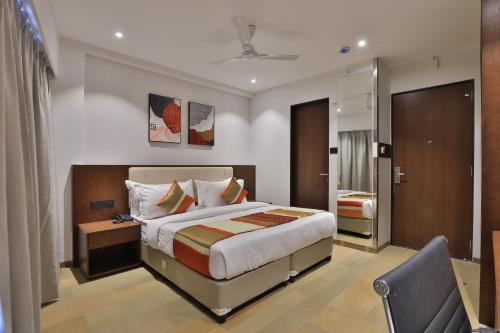 苏拉特Hotel Elements Surat的配有一张床和一把椅子的酒店客房