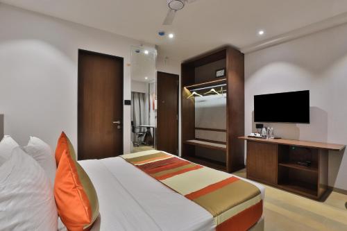 苏拉特Hotel Elements Surat的配有一张床和一台平面电视的酒店客房