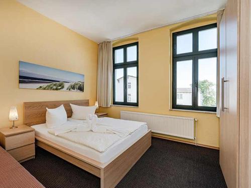 塞巴特阿尔贝克Strandvilla Ostpreussen - Dependance Strandhus的一间卧室设有一张大床和两个窗户。