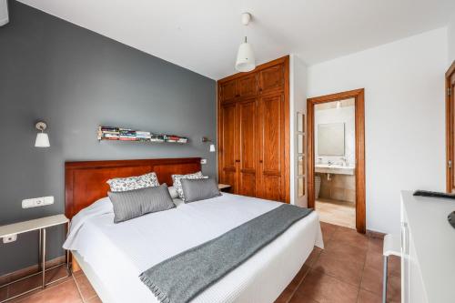 普拉亚布兰卡VILLAS LANZAROTE LOS ALTOS by NEW LANZASUITES Villa SERENA的卧室配有白色的床和木制床头板