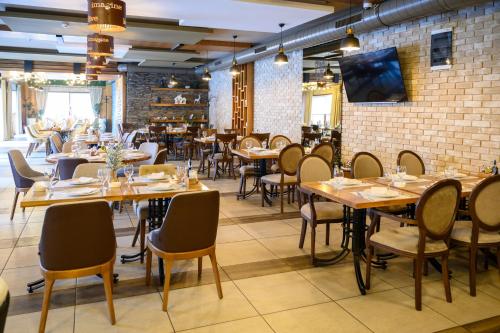 InđijaMV Monogram的餐厅设有木桌和椅子,拥有砖墙