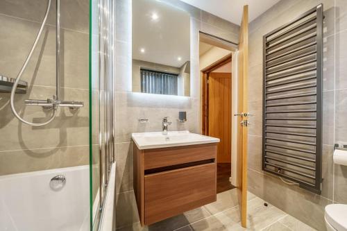 鲍内斯温德米尔Modern Bowness-on-Windermere Flat - Free Parking的一间带水槽和淋浴的浴室