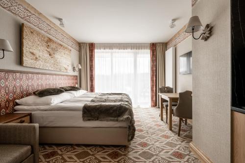 布科维纳-塔钱斯卡Aries Residence Bukowina的配有一张床和一张书桌的酒店客房