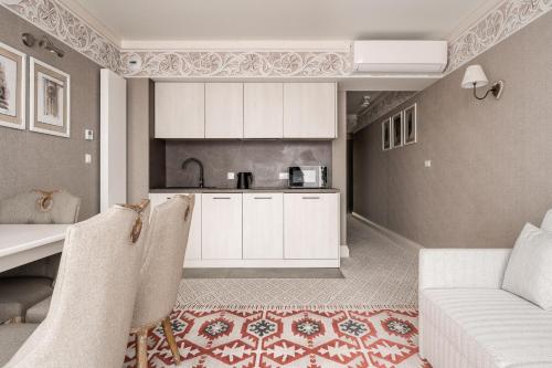 布科维纳-塔钱斯卡Aries Residence Bukowina的厨房配有白色橱柜、桌子和沙发