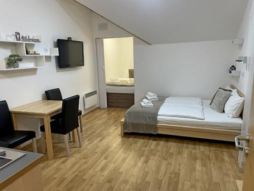马汀Martinske Hole, Apartman, Nova Ponorka的一间卧室配有一张床、一张桌子和一张桌子