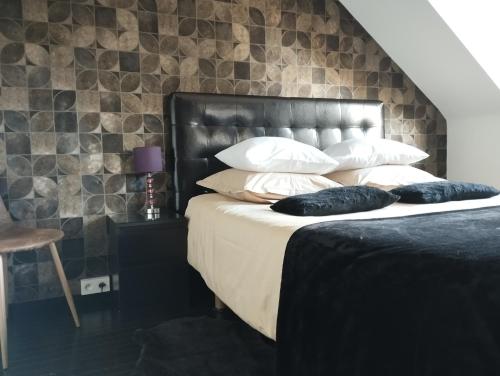 滑铁卢Sweetnest by home的一间卧室配有一张带黑色床头板和枕头的床。