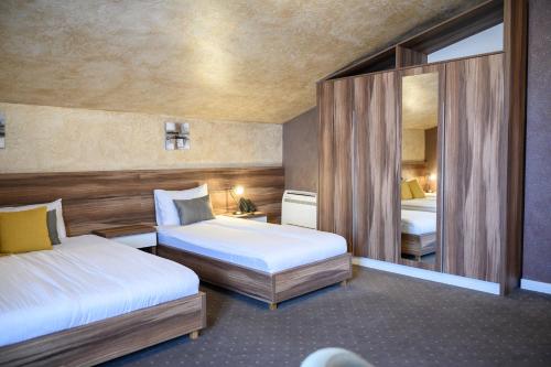 InđijaMV Monogram的酒店客房,设有两张床和镜子