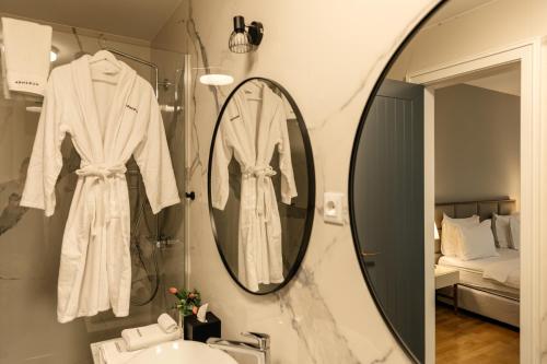 希贝尼克Armerun Heritage Hotel & Residences的浴室设有镜子和白色浴袍