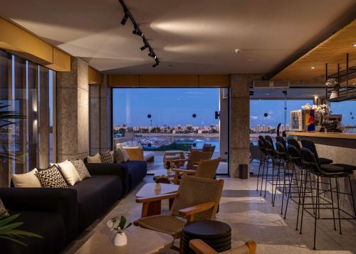 赫尔格达Creek Hotel and Residences El Gouna的带沙发和椅子的客厅以及酒吧。