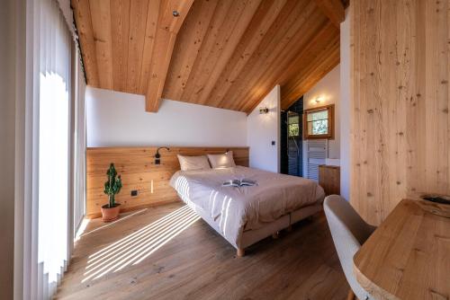 圣沙夫雷Chalet Ski Académie - Serre Chevalier的一间卧室设有一张床和木制天花板