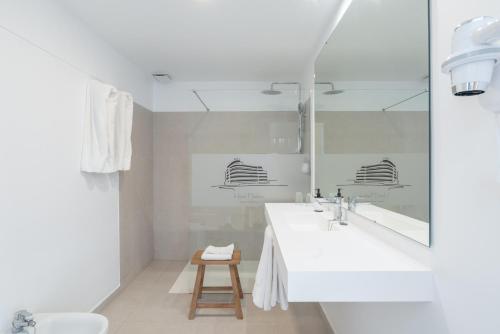 厄尔梅达诺梅达诺酒店的白色的浴室设有水槽和镜子