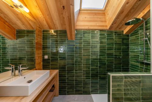 圣沙夫雷Chalet Ski Académie - Serre Chevalier的浴室设有水槽和绿色瓷砖淋浴。
