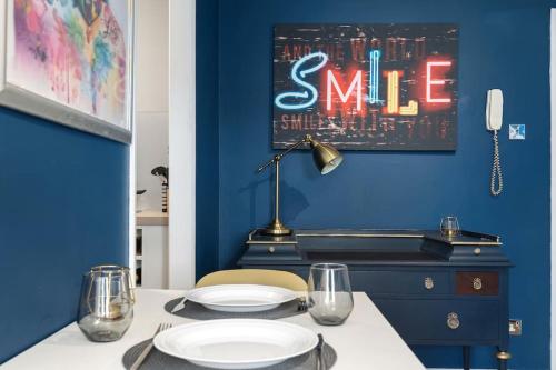 KentStudio Apartment in Central Maidstone的一间设有蓝色墙壁和一张带盘子的桌子的用餐室