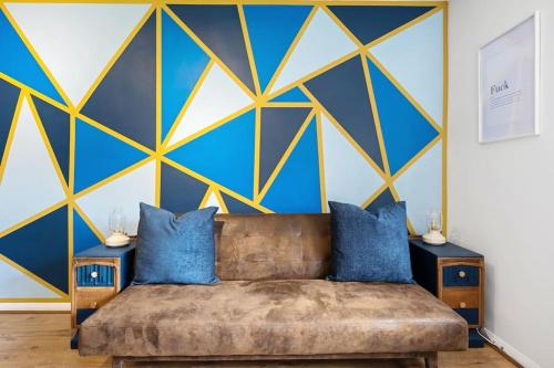 KentStudio Apartment in Central Maidstone的带沙发的客厅以及蓝色和黄色的墙壁