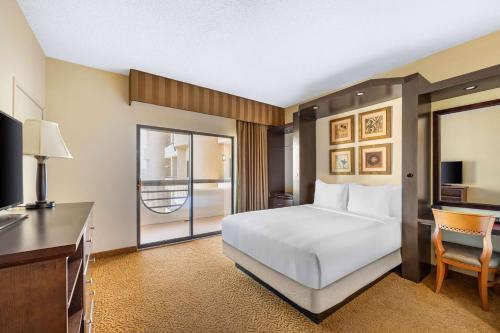拉斯维加斯Hilton Vacation Club Polo Towers Las Vegas的一间卧室配有一张床、一张书桌和一台电视