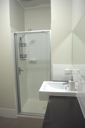 罗克斯比唐斯Modern Apartment in Roxby Downs的白色的浴室设有水槽和淋浴。