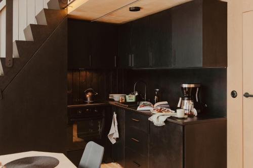 JodłówBłogostan的厨房配有黑色橱柜和楼梯