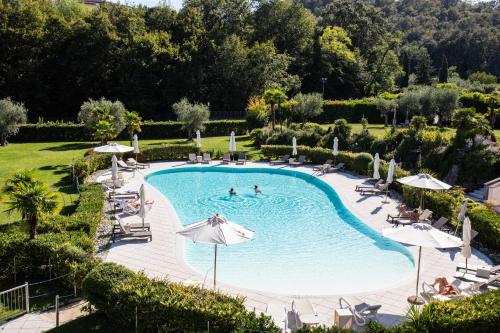 索亚诺德拉戈Monastero Resort & Spa - Garda Lake Collection的一个带椅子和遮阳伞的室外游泳池