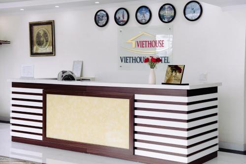 下龙湾VIET HOUSE HẠ LONG HOTEL的墙上挂有时钟的商店里的柜台