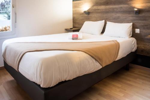 里摩日Fasthôtel - Un hôtel FH Confort的卧室配有一张带白色床单和枕头的大床。