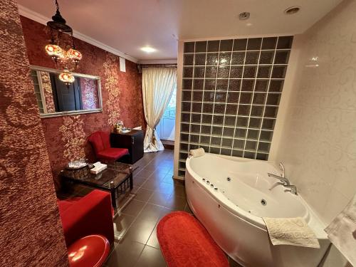切尔诺莫斯克尼卡酒店的带浴缸、椅子和桌子的浴室