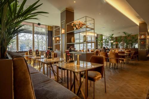 鹿特丹ART Hotel Rotterdam-Fully Renovated的一间在房间内配有桌椅的餐厅