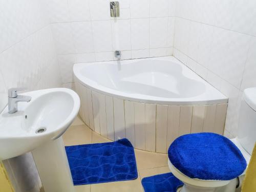利文斯顿Wanita Apartments的浴室配有盥洗盆、卫生间和浴缸。