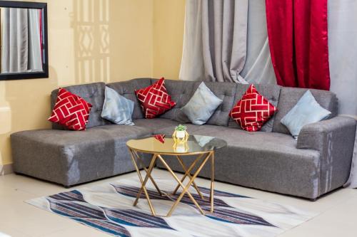 利文斯顿Wanita Apartments的客厅配有沙发、枕头和桌子
