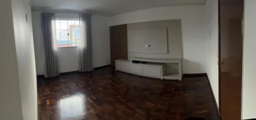 Siqueira CamposApartamento no Centro的一间空房间,设有厨房和木地板