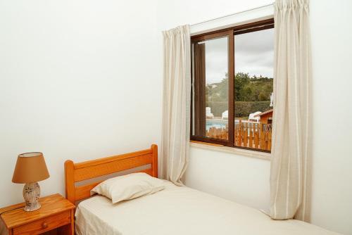 博利凯梅Boliqueime House的一间卧室设有两张床和窗户。