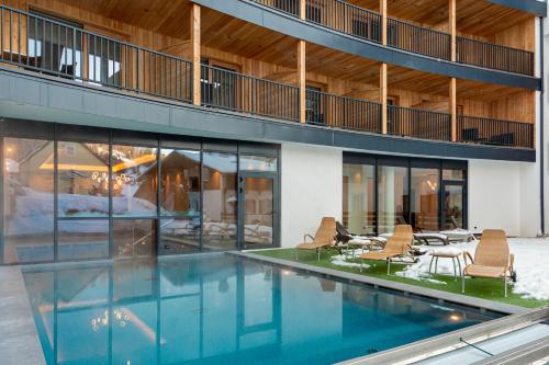 莫埃纳Monza Dolomites Hotel的一座带椅子的室内游泳池