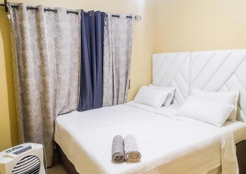 利文斯顿Wanita Apartments的一间卧室配有一张床,并备有2个拖鞋