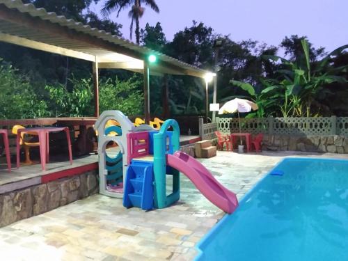 大普拉亚Pousada Recanto do Zeca casa 3的一个带滑梯和游乐场的儿童游泳池