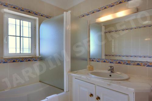 卢斯Jardim Secreto的一间带水槽、淋浴和镜子的浴室