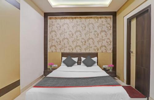 坎普尔Hotel Tirupati Galaxy的一间卧室设有一张大床和一面墙